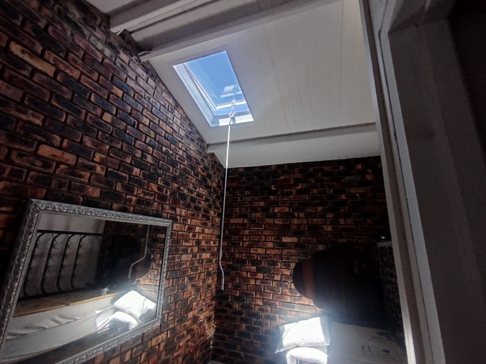Skylight installed in a loft-style room — natural light complementing exposed brick character