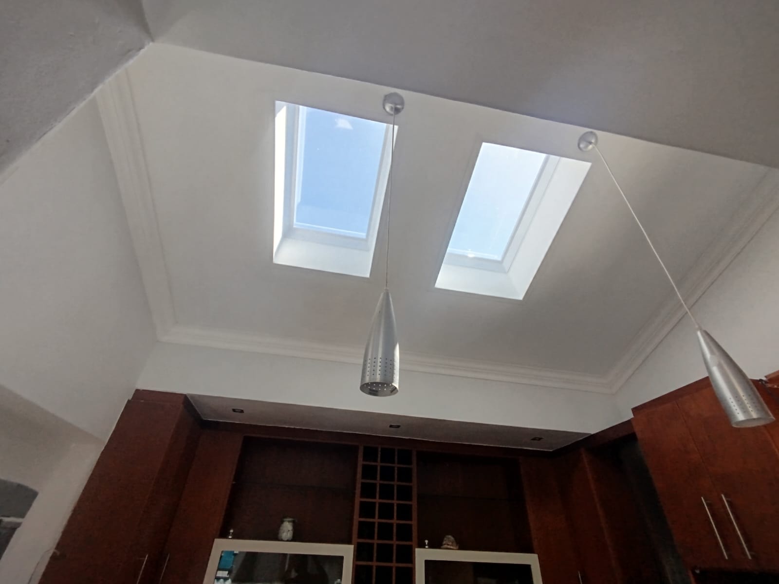 Two skylights flooding a kitchen with natural light alongside pendant lighting