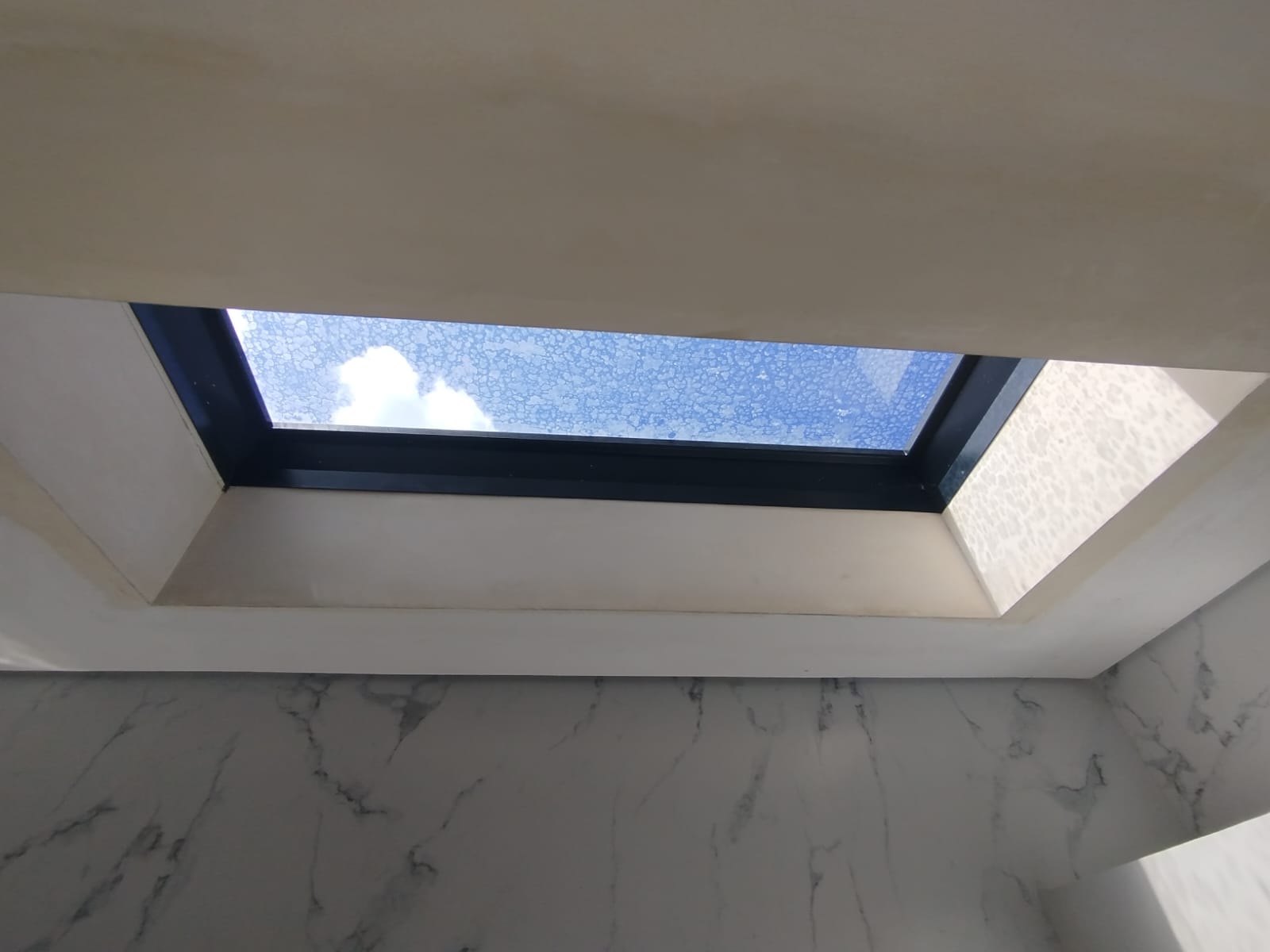 Skylight installation in progress — ceiling opening with blue sky view